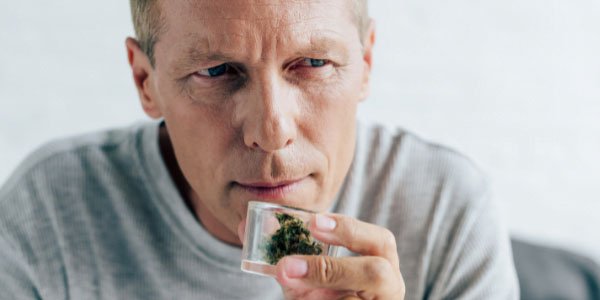 A guy smelling Bio Jesus cannabis strain